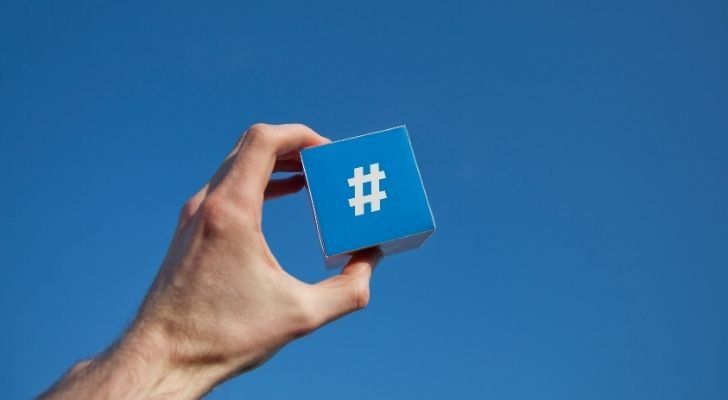 Someone is holding a blue pad with a white hashtag on it